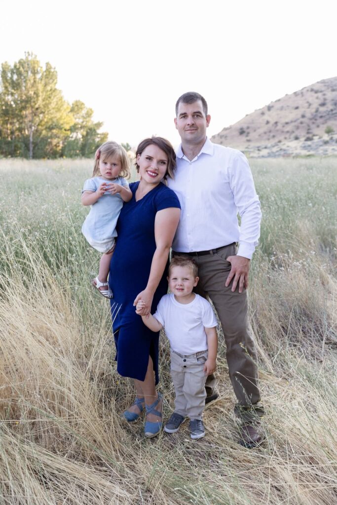 Reid Pinther with his wife and two young children in a golden field in Boise